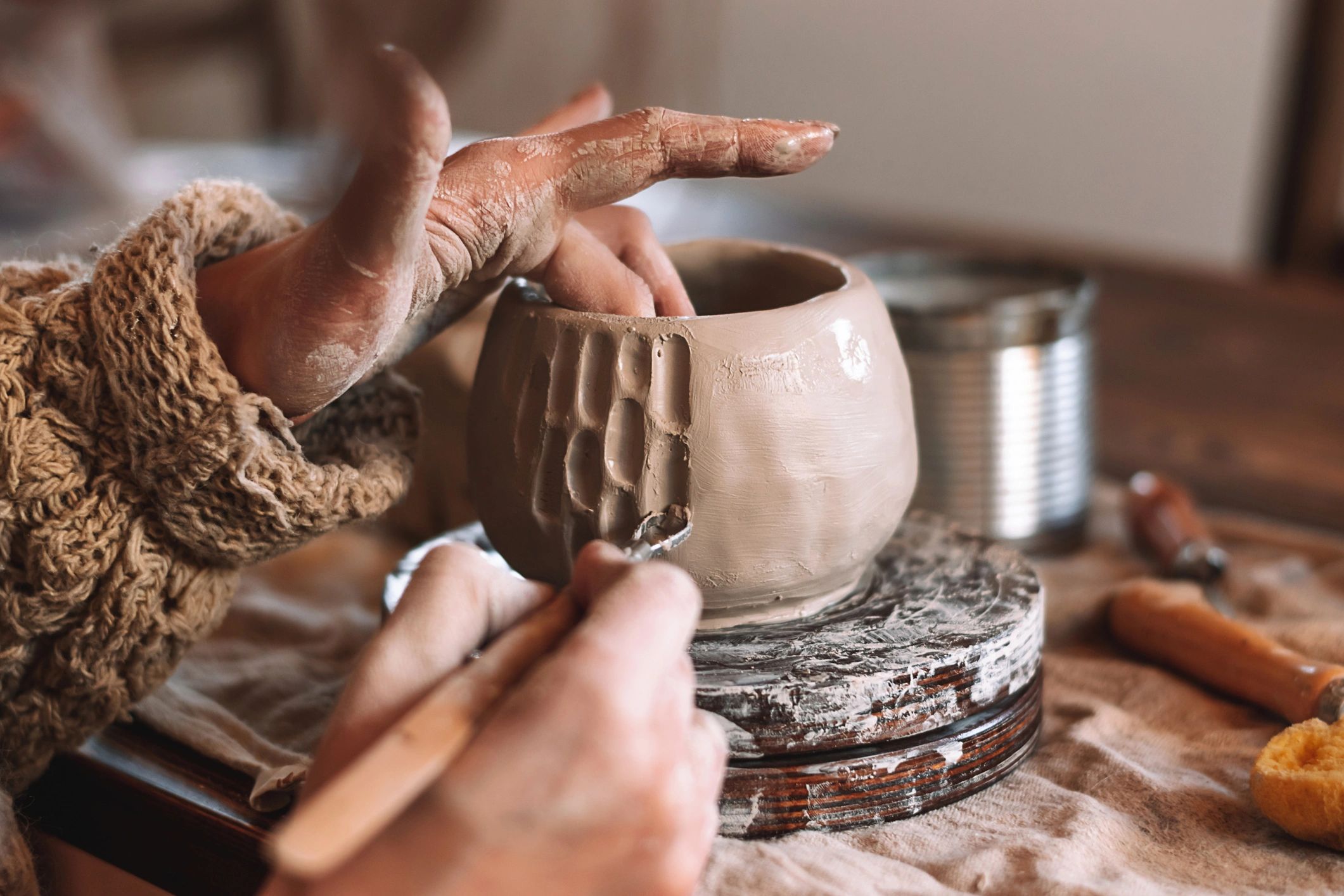 Hands shaping clay during a studio process