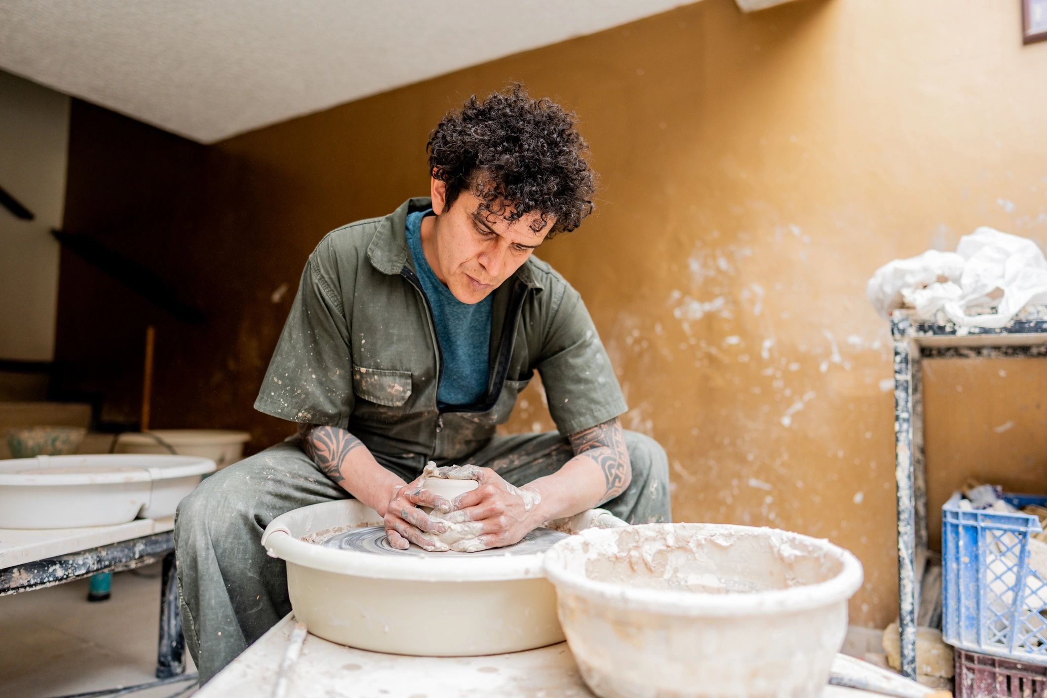 Artist shaping clay in a workshop